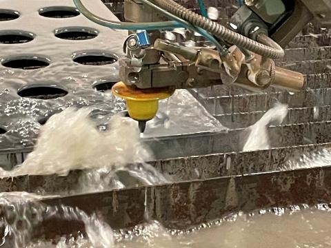 The flow waterjet in action cutting quarter inch steel for a product design student.