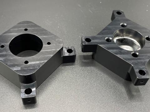 A lens mount made from aluminum and then anodized black.